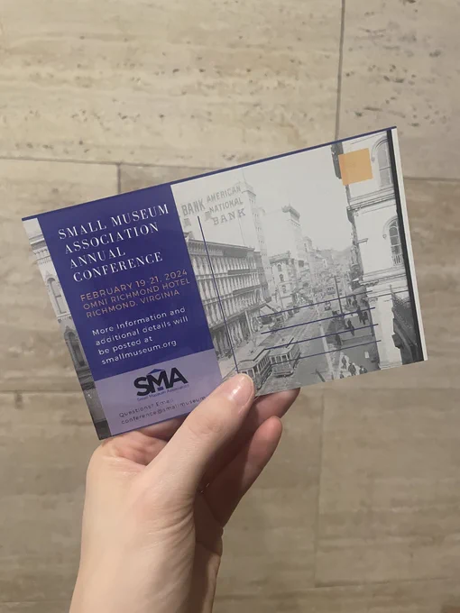 Postcard for SMA 2024 held against a marble wall.