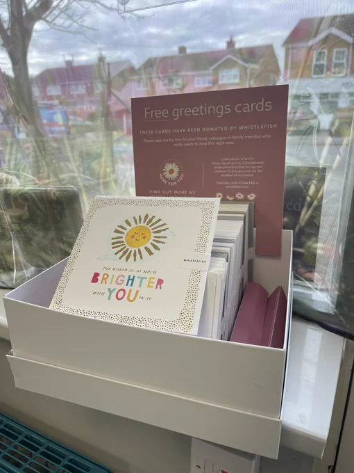 Box of greetings cards with sign saying Free, please take one.