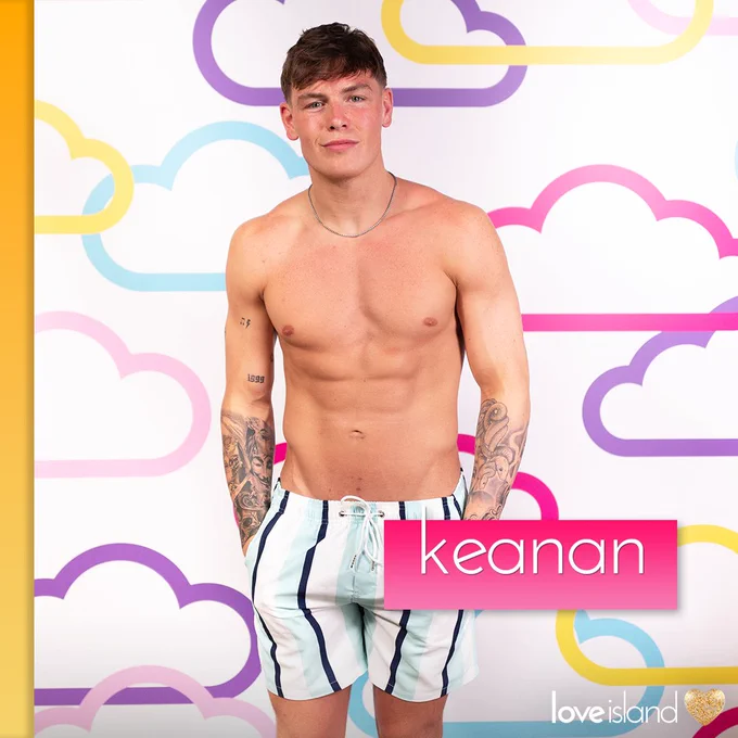 Keanan poses in blue, black and blue striped swimshorts.