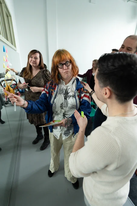 Artists adding post it notes to a mirror with their ideas 