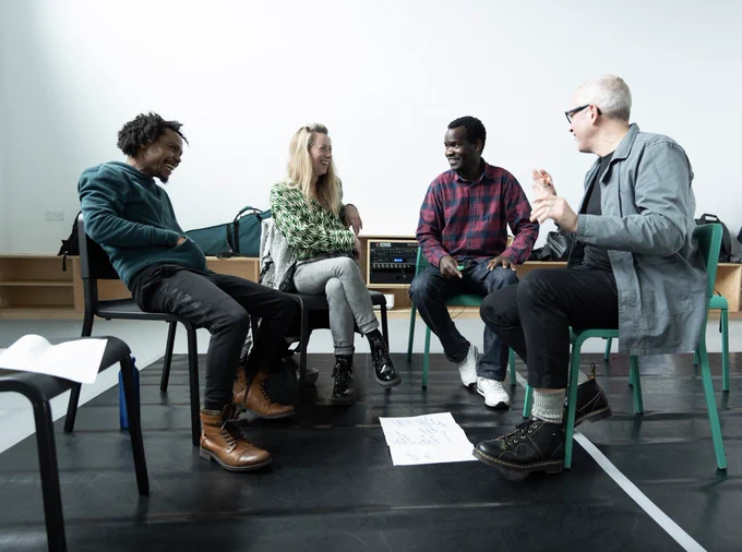 A group of artists laughing during a workshop