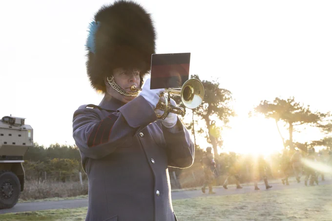 A member of the Household Division plays the bugle as the sunrises in the background.