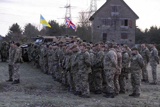  A group of Ukrainian recruits stand in line in front of a training building.