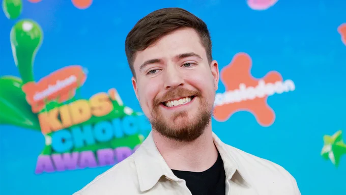 Closeup of MrBeast in front of a Nickelodeon Kids' Choice Awards step and repeat. 