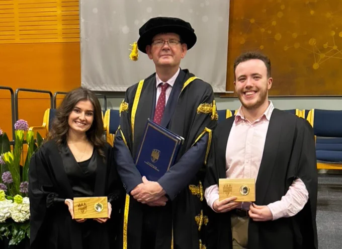 Photo: UCD students Maia Springael and Ryan Moran holding their preisdent's awards beside acting UCD President Prof Mark Rogers