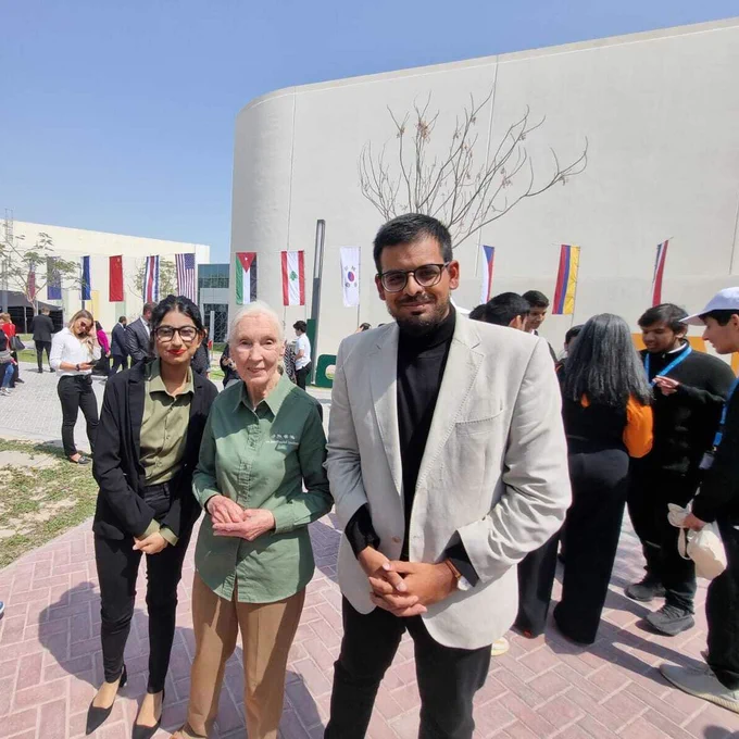 Jane Goodall standing between a young woman and a young man.