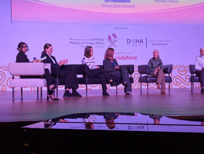 Five panelists sit on stage, Jane Goodall on the very right. 