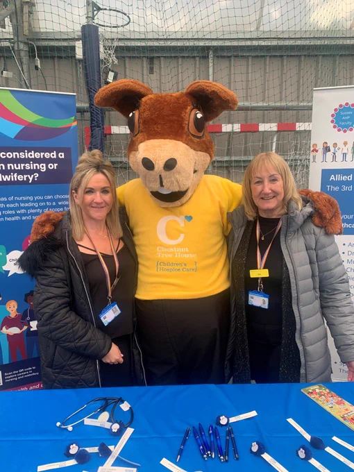 ESHT Integrated Education members of staff posing with the Chestnut Tree House Squirrel mascot at Eastbourne Schools Careers Fair, 10th March.