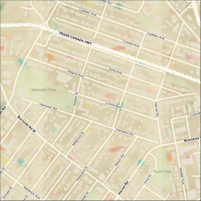 This is an extremely-close up image of an aerial view map of a residential area. The land mass of Canada has been turned a fluffy-textured beige and multicoloured “fun-fetti” vanilla cake texture. Buildings and roads are symbolized in a way that resembles white buttercream frosting. 
