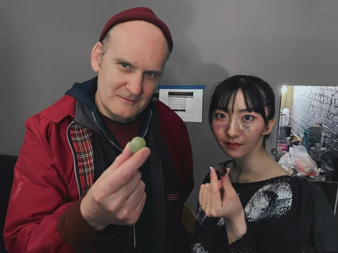 A photo of Ian MacKaye and Haru Nemuri holding a grape with their finger.

指でぶどうを持っているイアン・マッケイと春ねむりの写真