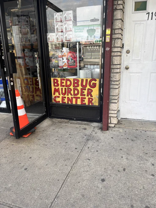 Yellow sign with red handwriting that says “BEDBUG MURDER CENTER” in the window of a hardware store.