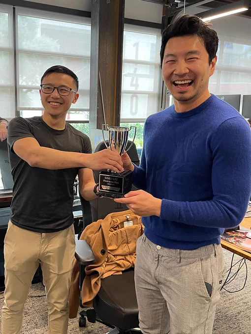 Kevin "Monk" Dong presents Simu Liu with a commemorative Stormgate trophy. 