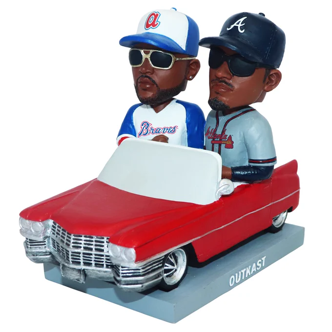A bobblehead featuring Outkast in Braves jerseys while riding in a red convertible.