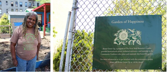 Karen Washington, a Black woman in a brown tee shirt and jeans stands by a garden of happiness sign. 