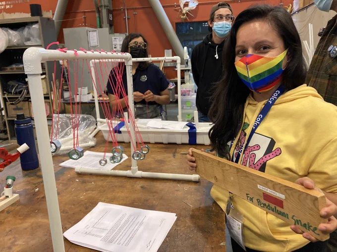 An educator working on building their own version of the pendulum snake at the Exploratorium workshop