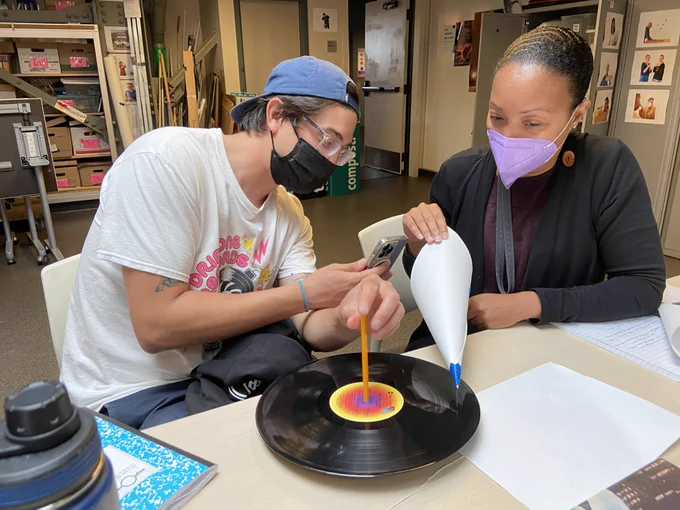 Two educators working on an activity involving a vinyl record