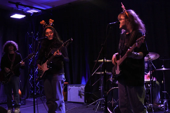 Students performing with guitars and bass guitar
