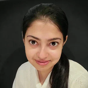 Dooti Roy is an Indian woman with long dark hair smiling slightly at the camera. 