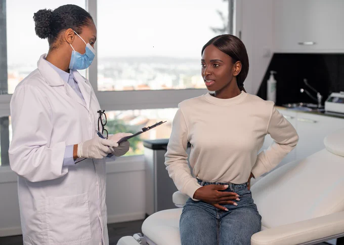 Woman at her check-up, speaking with a clinician. 