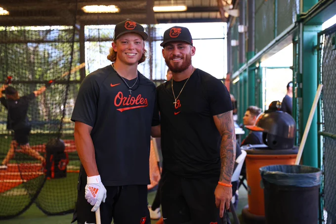 Jackson Holliday and Joey Ortiz smile for a photo together outside the batting cages with their arms around each other