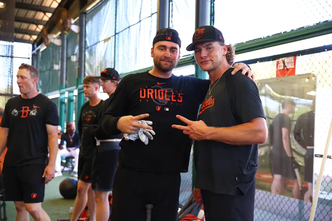 Colton Cowser and Gunnar Henderson pose for a photo together flashing peace signs during a break in the batting cages