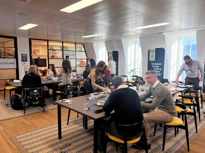 An image of people sat around tables talking 