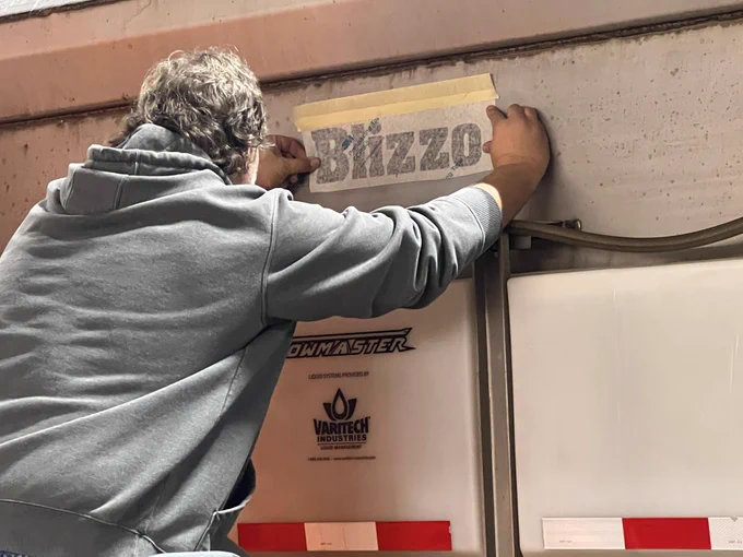Image of "Blizzo" name being placed on the snowplow.