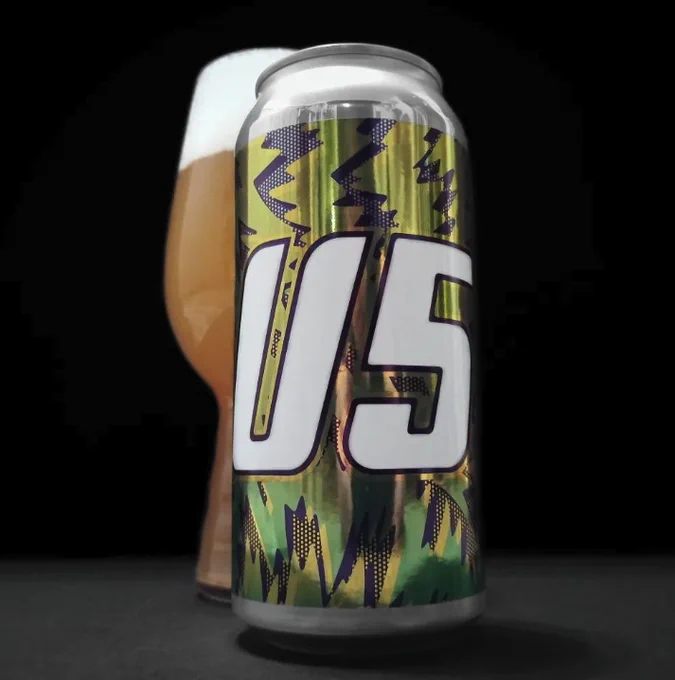 Can of beer in front of a full glass of beer with a black background.