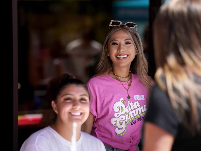 two students in delta gamma attire smiling at the camera