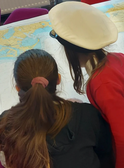 School children taking part in an activity using maps.