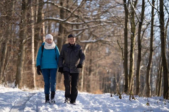Older couple walking along snowy path
