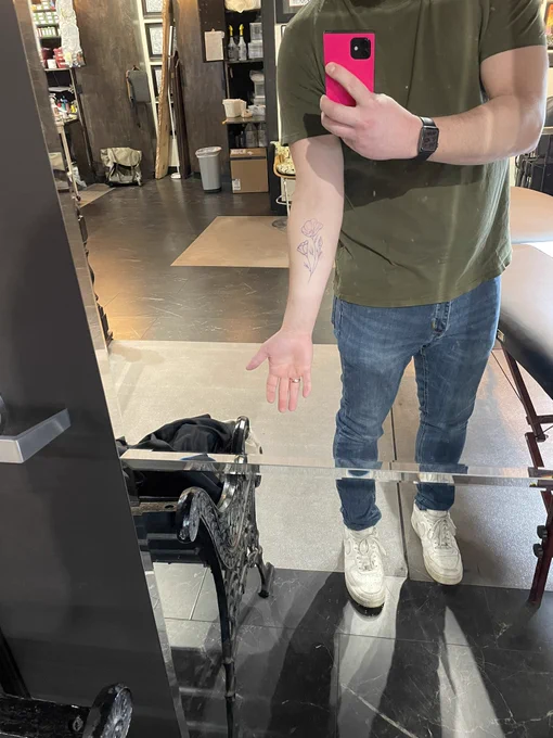 Standing with a stencils of a california poppy tattoo on my forearm