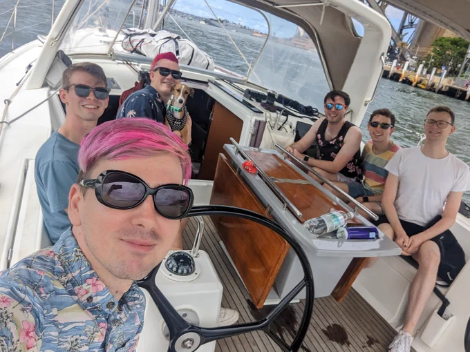 Photo of six gays and a (not human) puppy on a yacht, with yours truly at the helm.

The Sydney Harbour Bridge and Opera House are /technically/ visible, but it was pretty much impossible to fit everyone in and show where we were.
