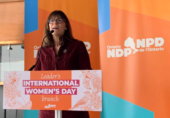 MPP Teresa Armstrong is standing at the lecturn addressing the crowd.
