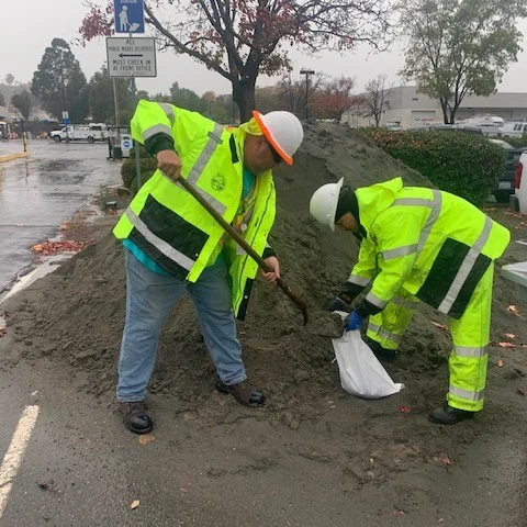 photo of two men filling sandbags