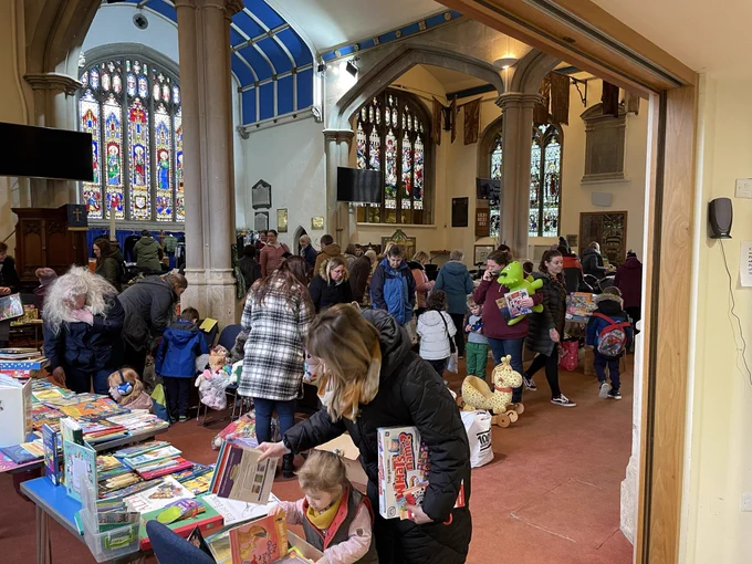 Inside St James Church in Devizes, very busy with people browsing a book and toy swap