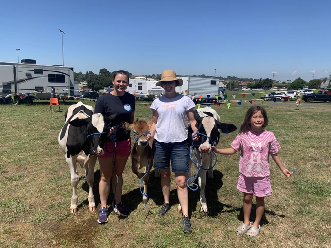 3 dairy calves posing with Beth Scott, Jennie Pryce and Jennie's daughter