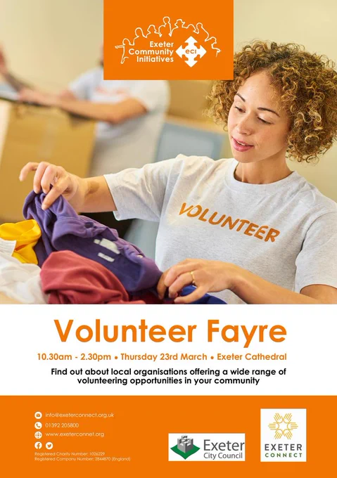 A volunteer folding clothes on a poster with event details listed