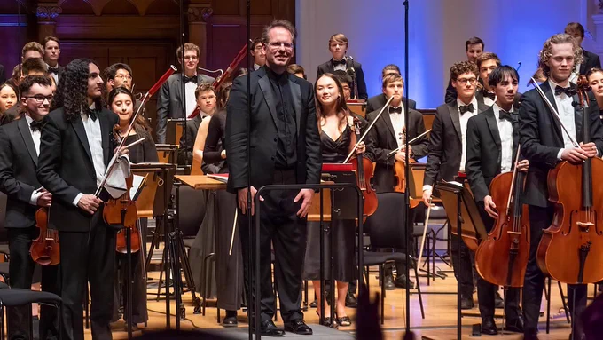 Oliver Gooch and the ICSO standing on stage. 