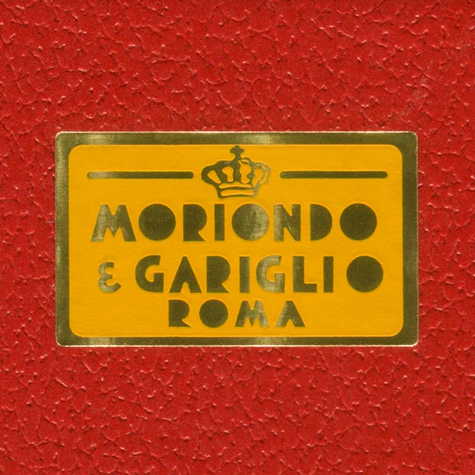 Orange and gold sticker which reads “Moriondo e Gariglio • Roma” on a red box.