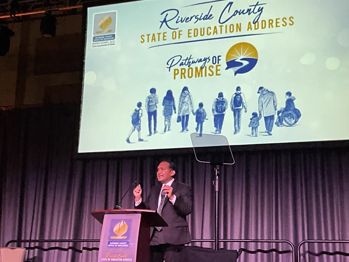 Dr, Edwin Gomez starting his 2023 Riverside County State of Education Address. Slide above stage is “Riverside County State of Education Address, Pathways of Promise” banner image.