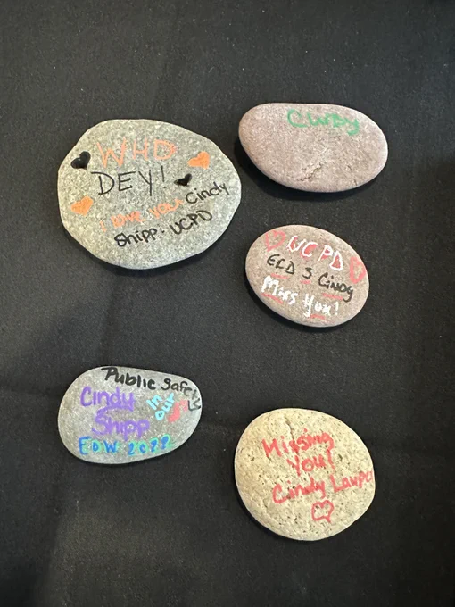 Rocks with painted messages remembering Cindy Shipp lay on a table.