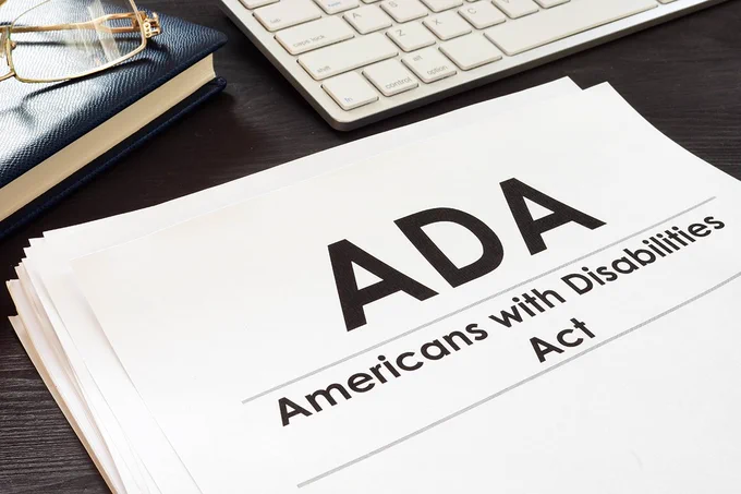 A stack of papers title "ADA: Americans with Disabilities Act."