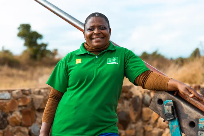 Woman stands in front on borehole