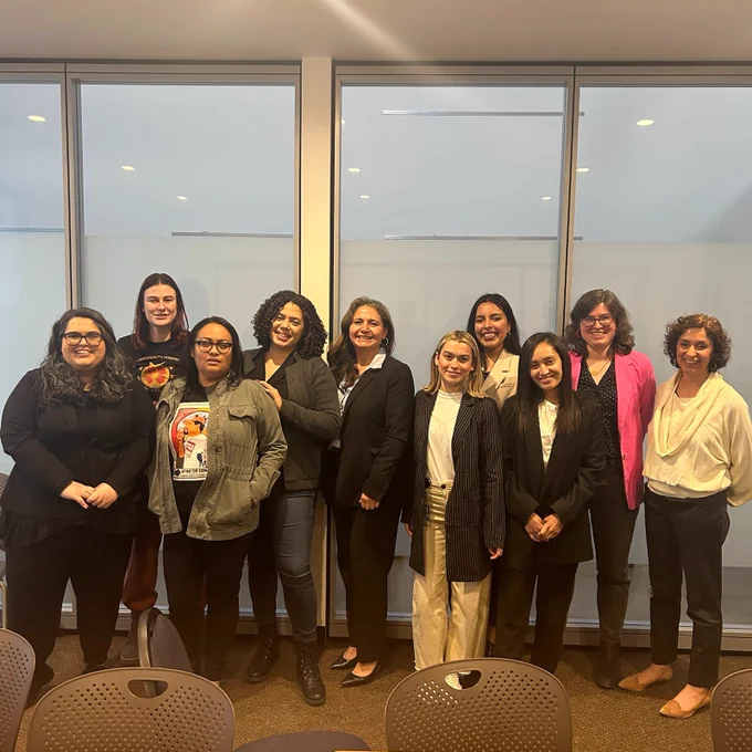 The women of CD13 are standing and smiling for a photo in our Echo Park field office. 