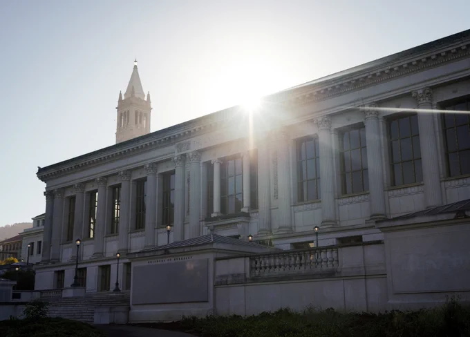 The sun gleams behind the north facade of Doe Library.