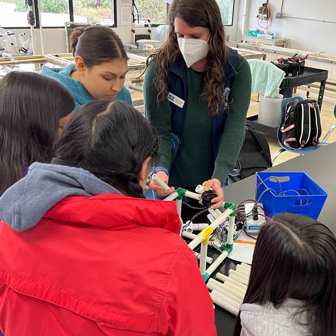 Students building underwater robots during design challenge with the help of Lindsay Carroll.