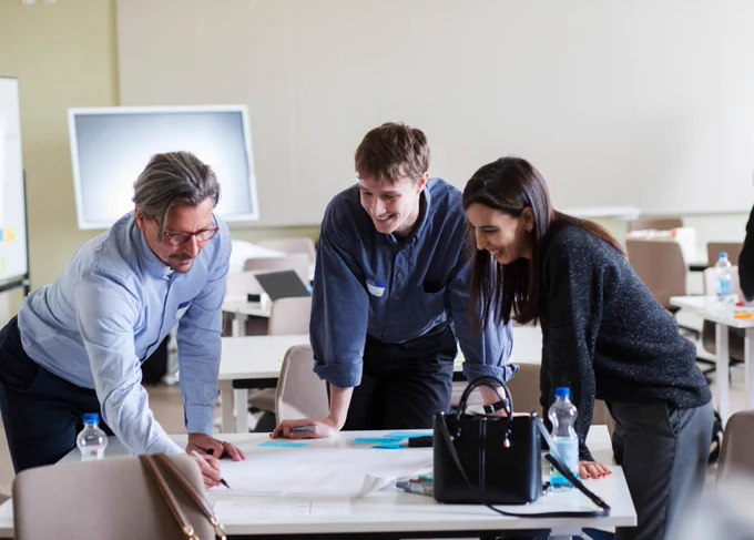 Professor Teemu Roos and two partners drawing a marketing plan