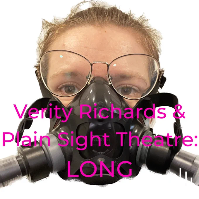 A photo of a white woman with glasses wearing a large face mask with tubes. Overlaid pink text reads "Verity Richards & Plain Sight Theatre: LONG".