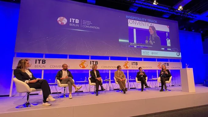 Image shows Claire Whitely, Head of Environment at the Sustainable Hospitality Alliance, speaking on stage at ITB Berlin alongside fellow panellists.